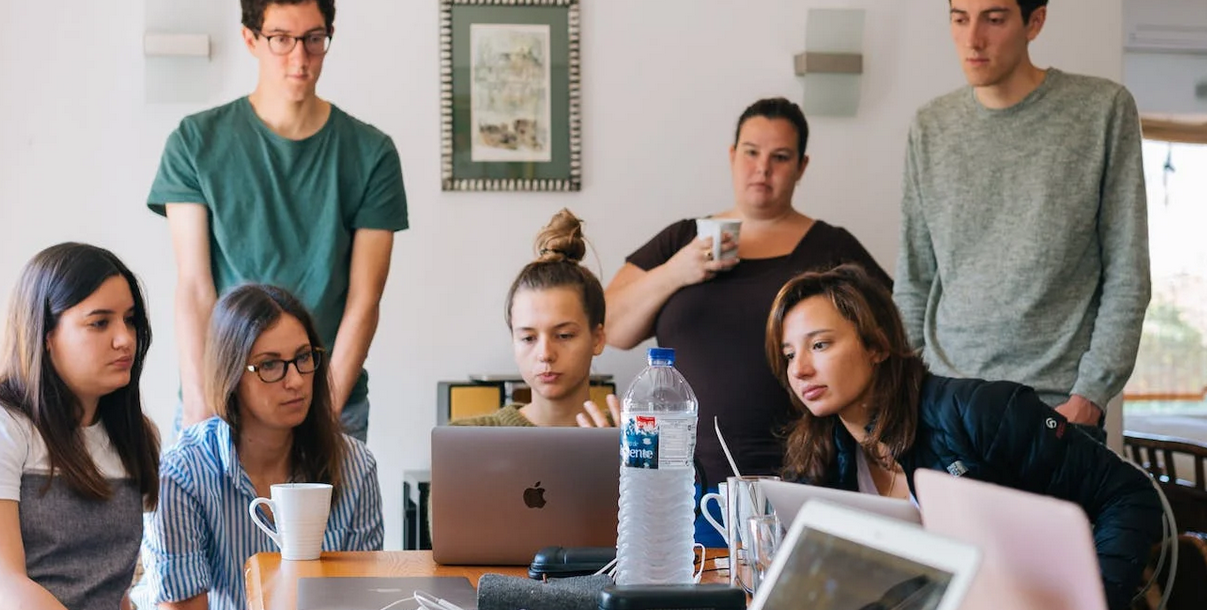 Grupo de jovens em redor de um pc portatil
